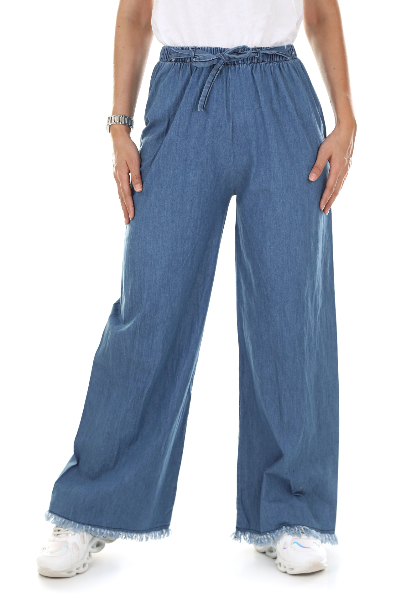 Woman in white tee and drawstring wide-leg chambray trousers with frayed hem, studio shot