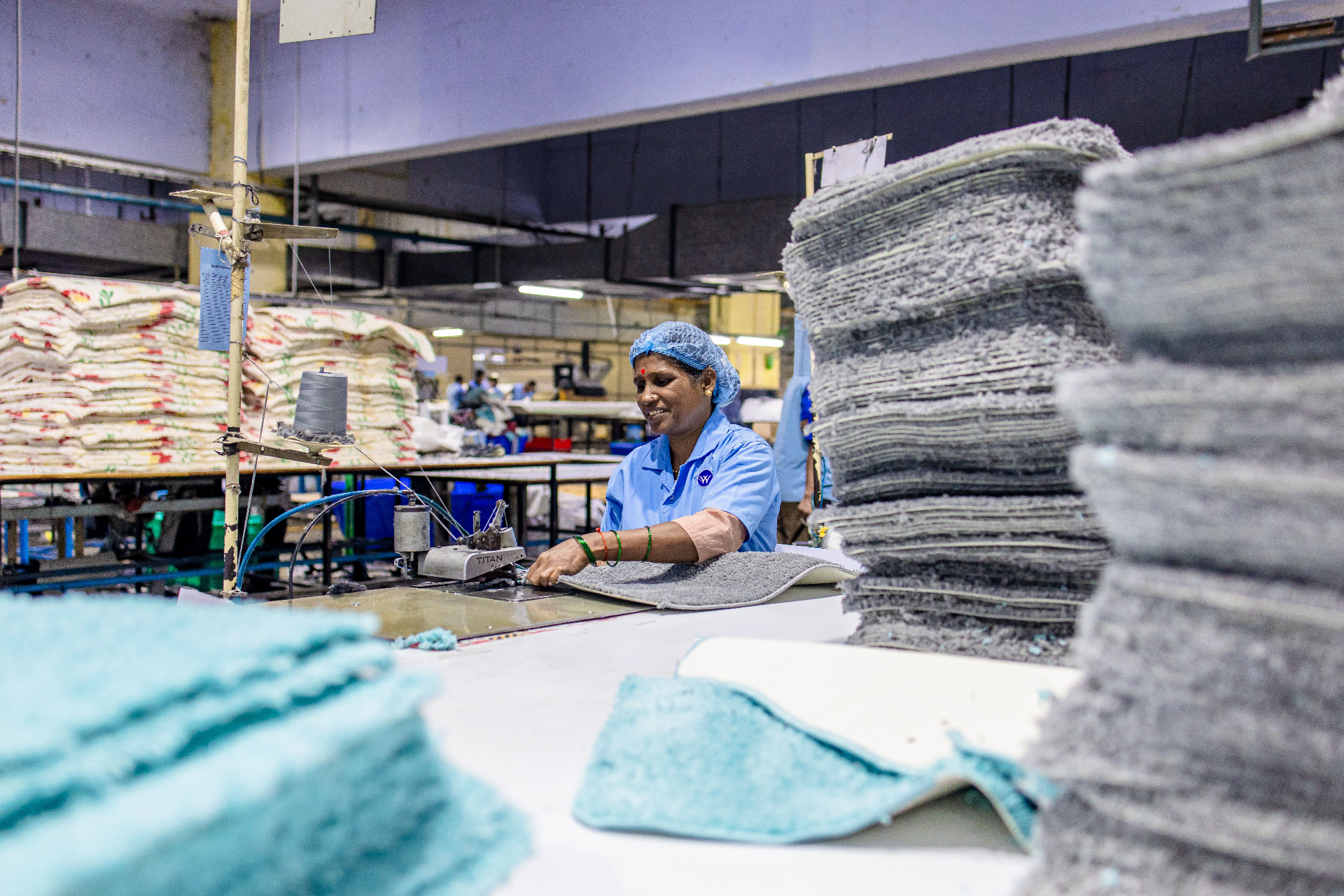 Smiling garment worker at a sewing station in a Bangladesh factory