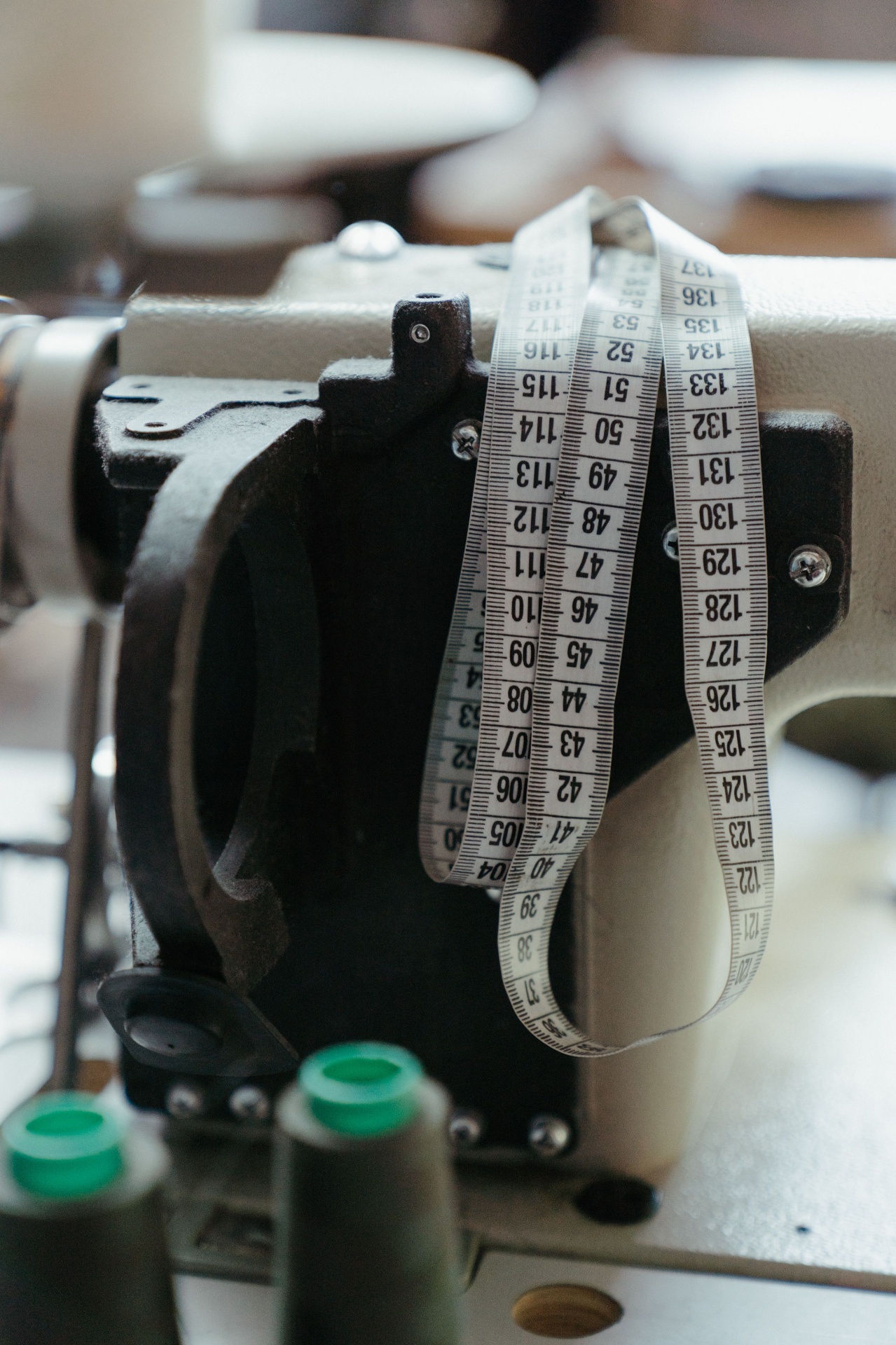Tape measure draped over an industrial sewing machine