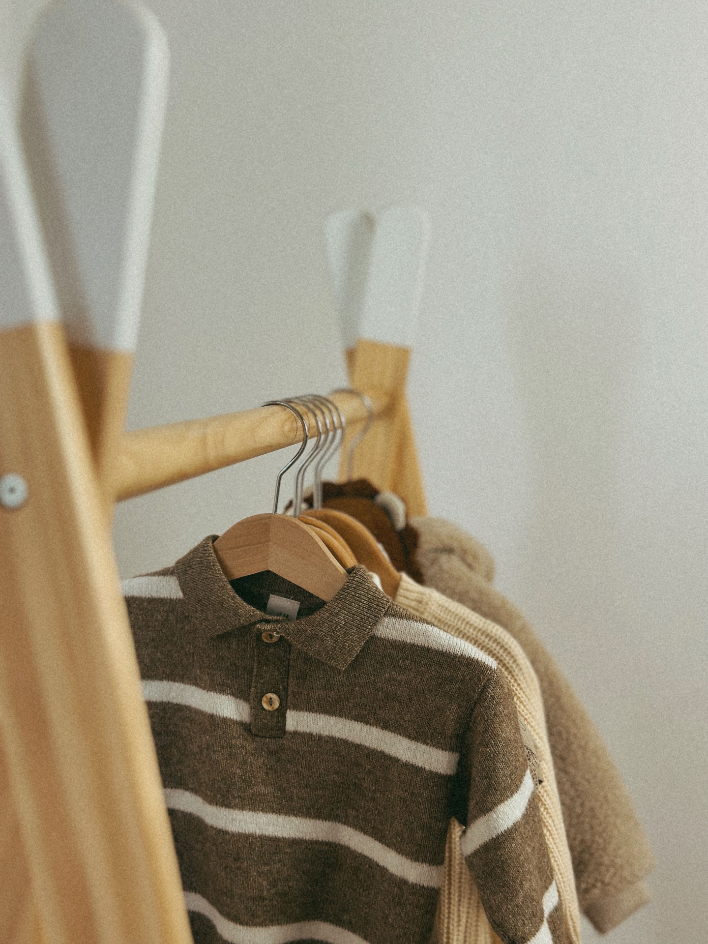 Striped brown knit polo on a wooden rack