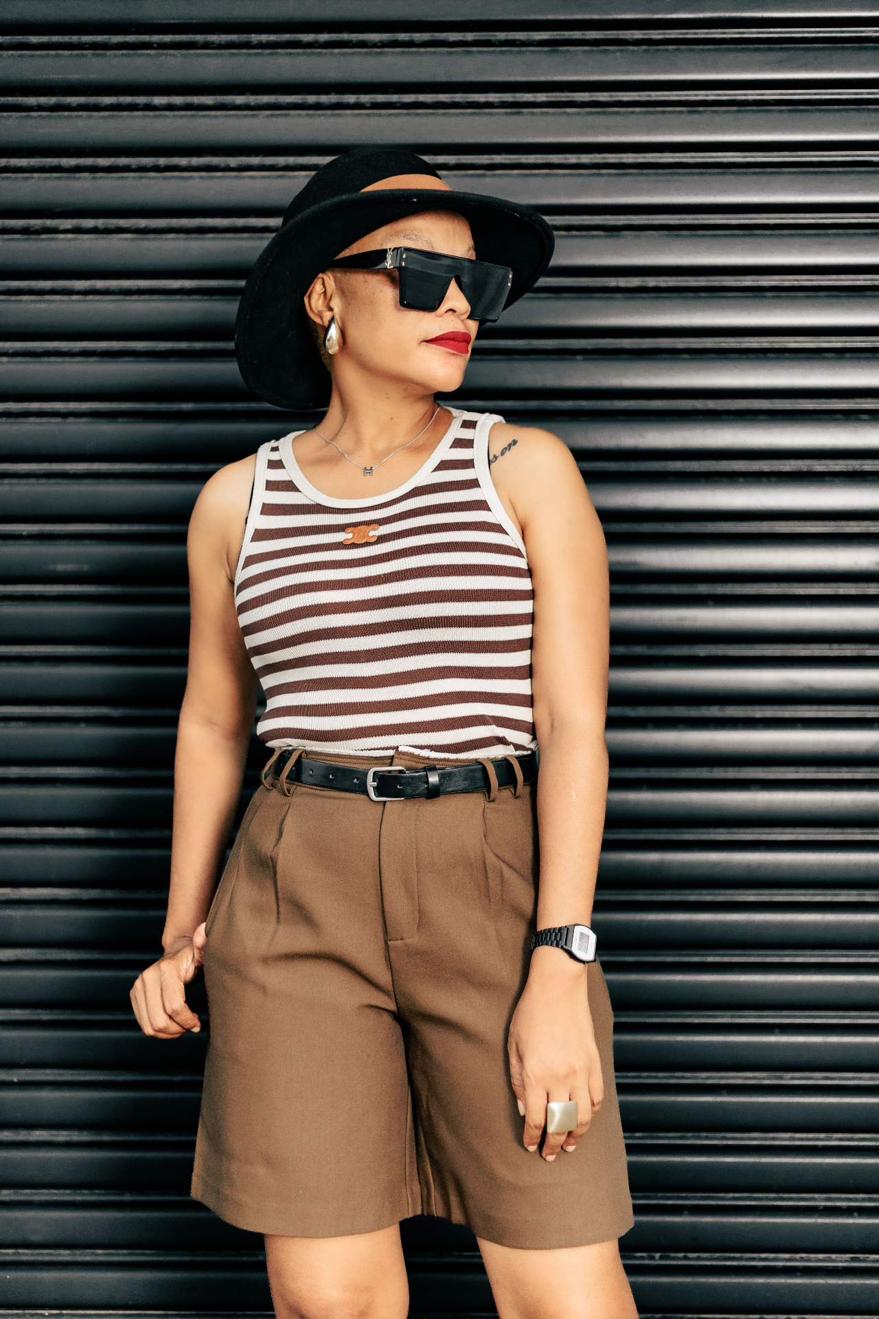 Woman in brown striped ribbed tank and tailored brown shorts