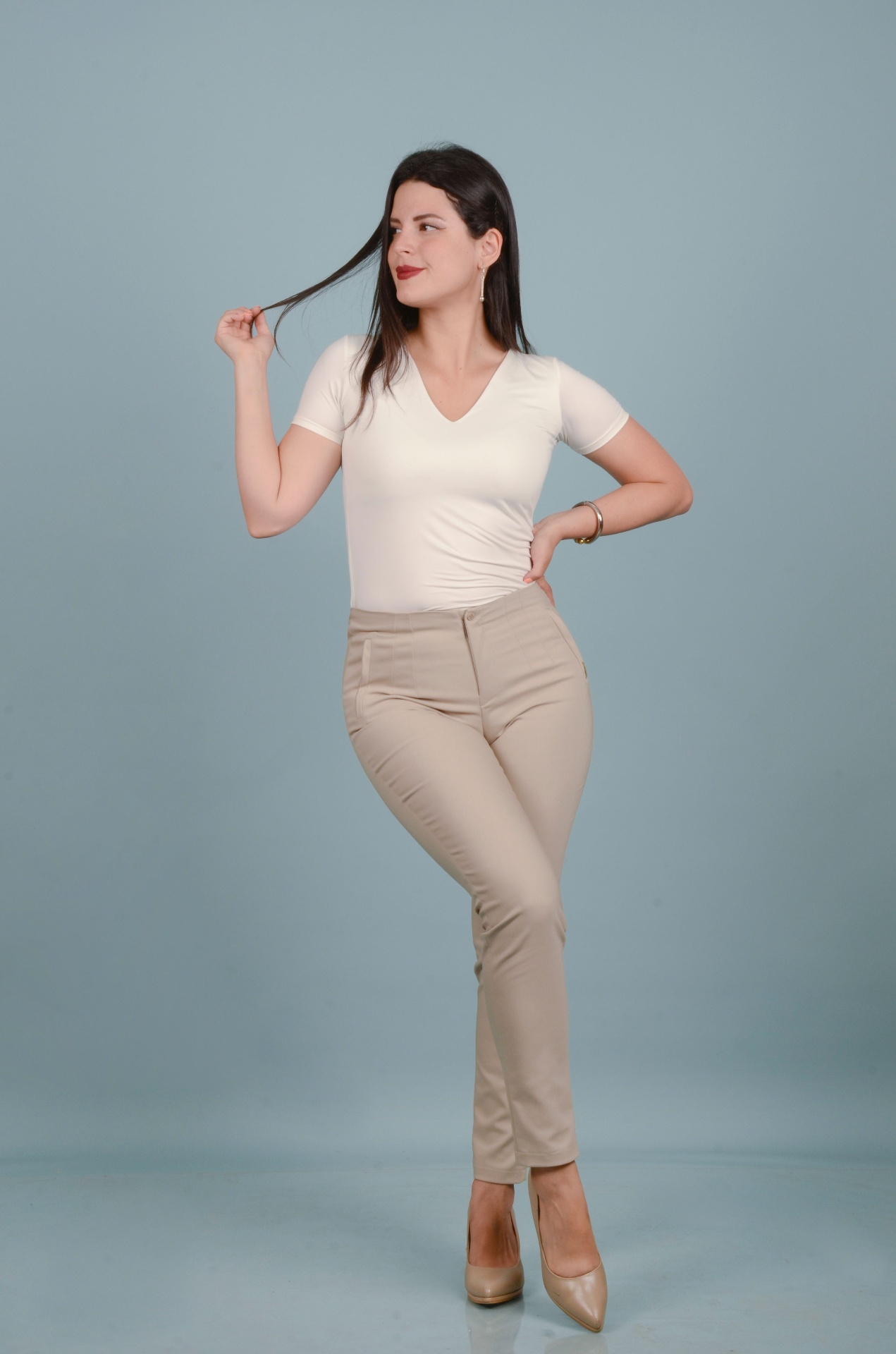 Woman in a soft white v-neck tee against a blue backdrop