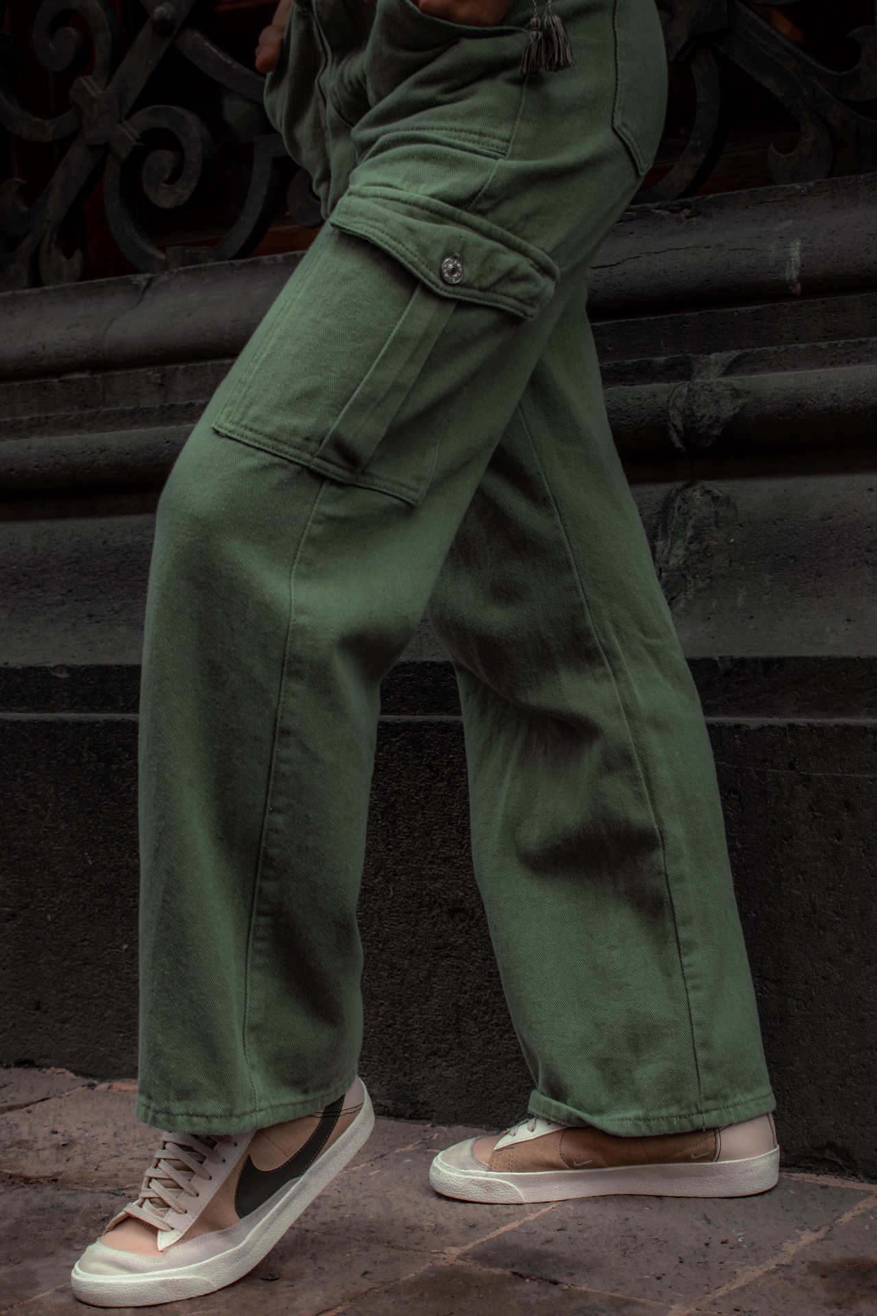 Olive green cargo trousers worn on city steps