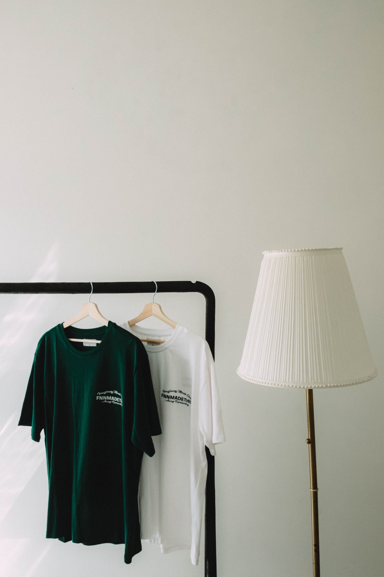 Green and white branded tees hanging on a rack